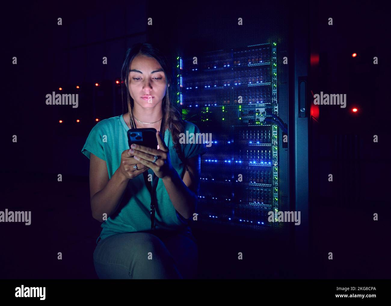 Technician using smart phone in server room Stock Photo
