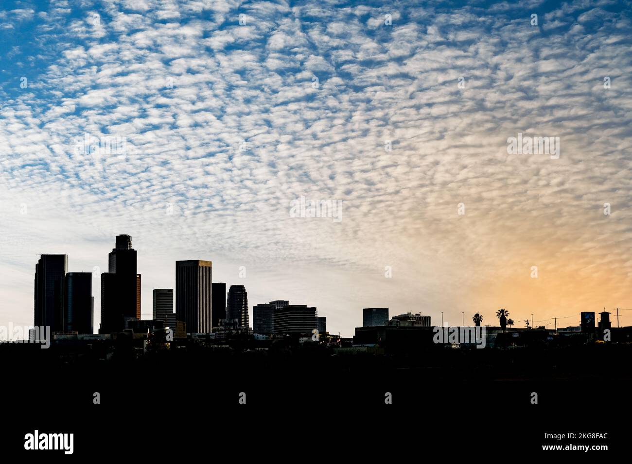 The skyline of Los Angeles downtown silhouette against a blue sky with ...