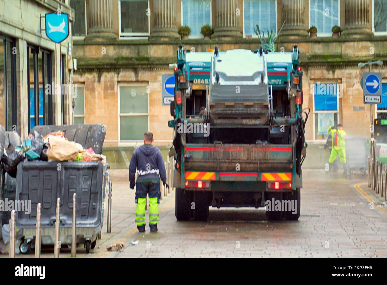 binmen with bin lorry emptying Stock Photo