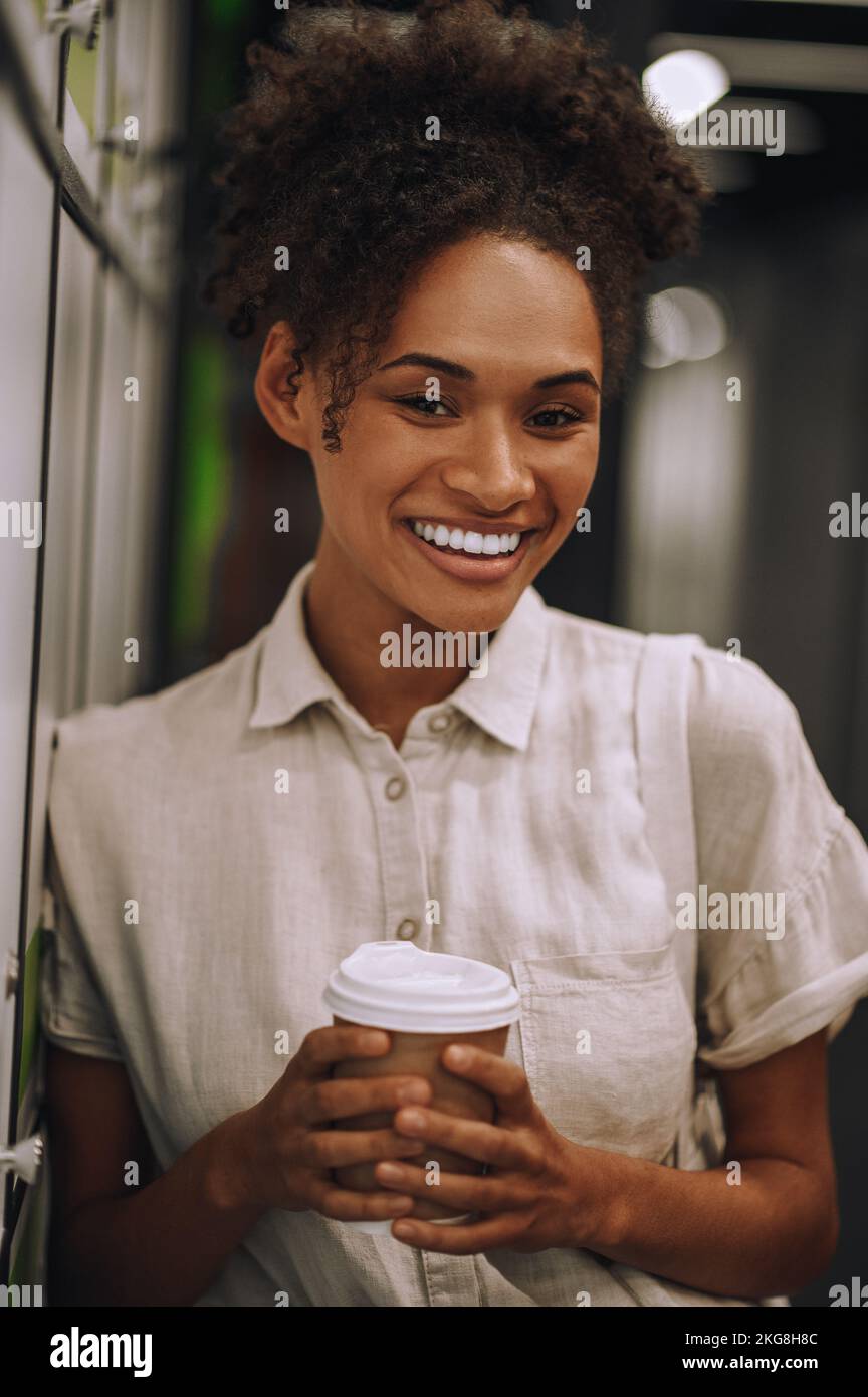 Joyous employee with a disposable coffee paper cup posing for the ...