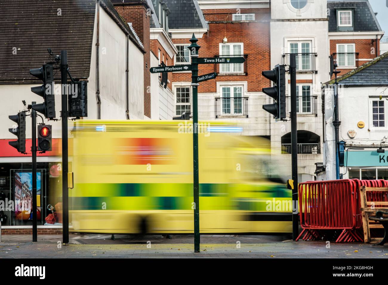 Epsom, Surrey, London UK, November 20 2022, Ambulance Passing Traffic Lights On A High Street With Blurred Effect To Indicate Speed And Motion Stock Photo