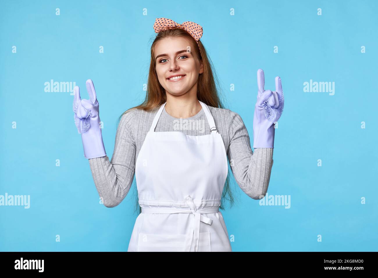 woman in rubber gloves and cleaner apron showing rock sign Stock Photo ...