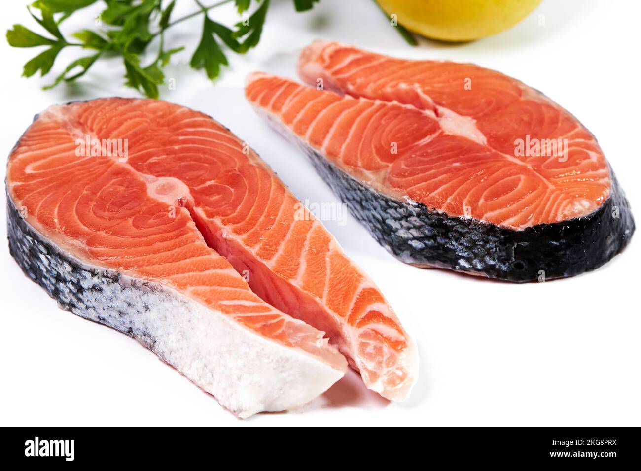 Salmon, slice of fresh raw fish with parsley and lemon, isolated on white background, trim path Stock Photo