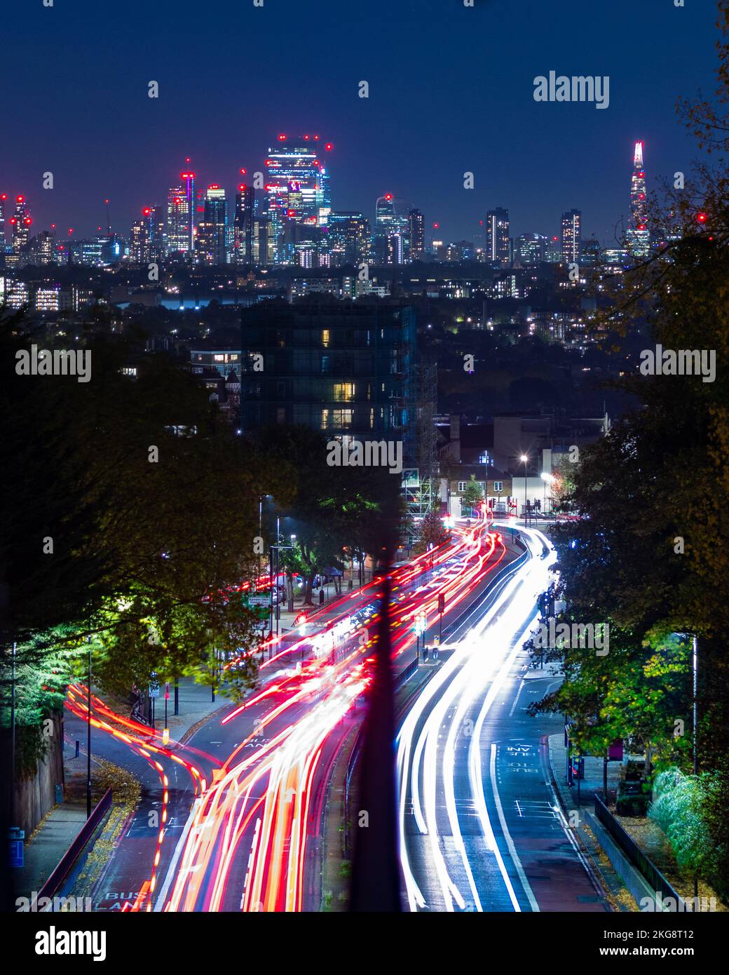 A view of the London skyline taken at night with light trails, showing a range of important and famous buidings against the back drop of a blue night Stock Photo
