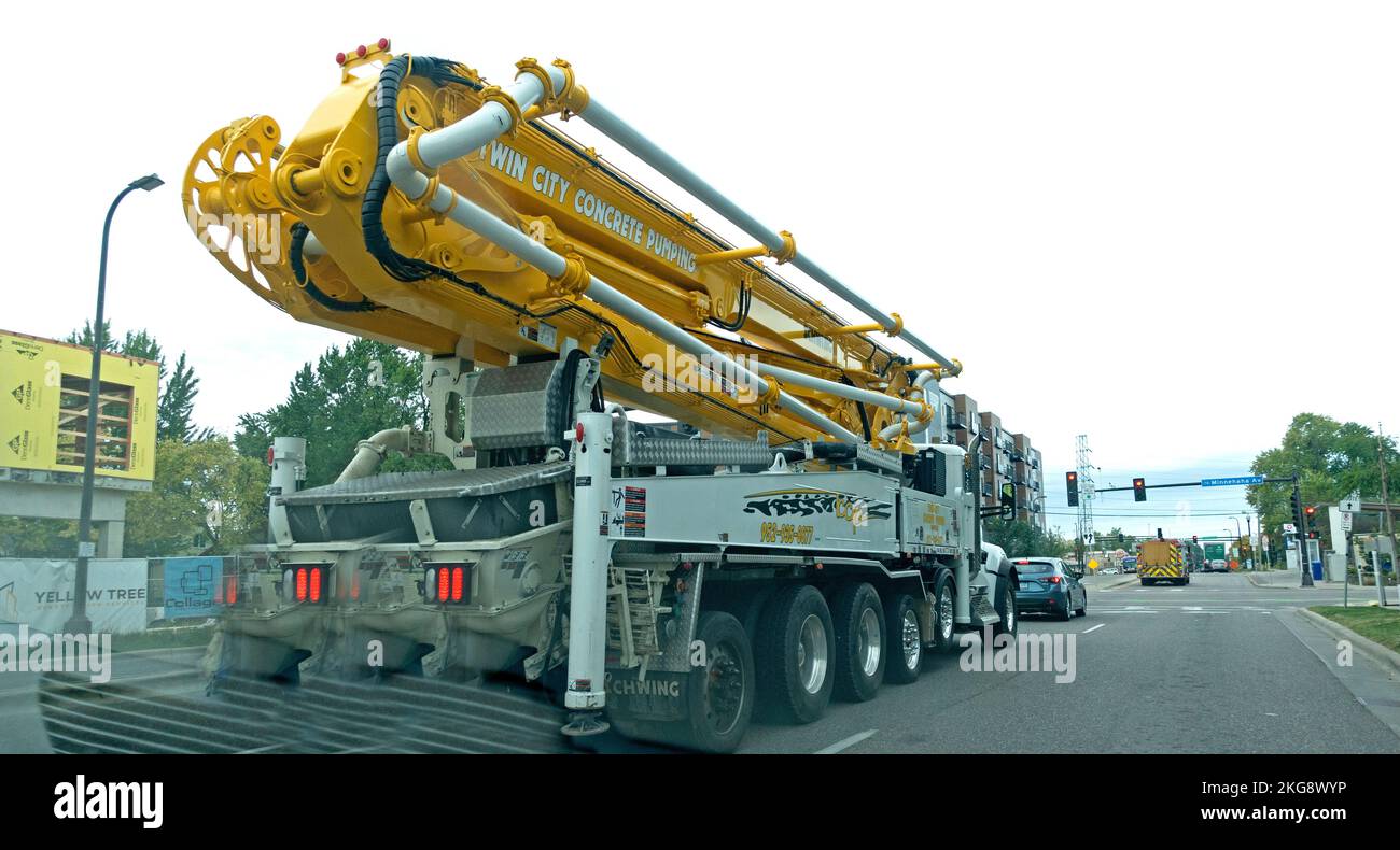 Transporting large yellow concrete pumper on the road for building construction. Minneapolis Minnesota MN USA Stock Photo