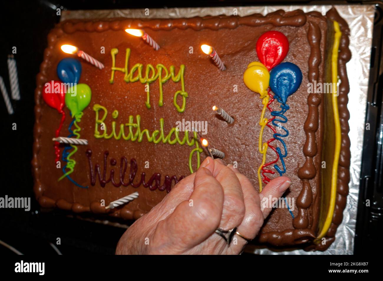 Lighting candles on William's chocolate birthday cake. St Paul Minnesota MN USA Stock Photo
