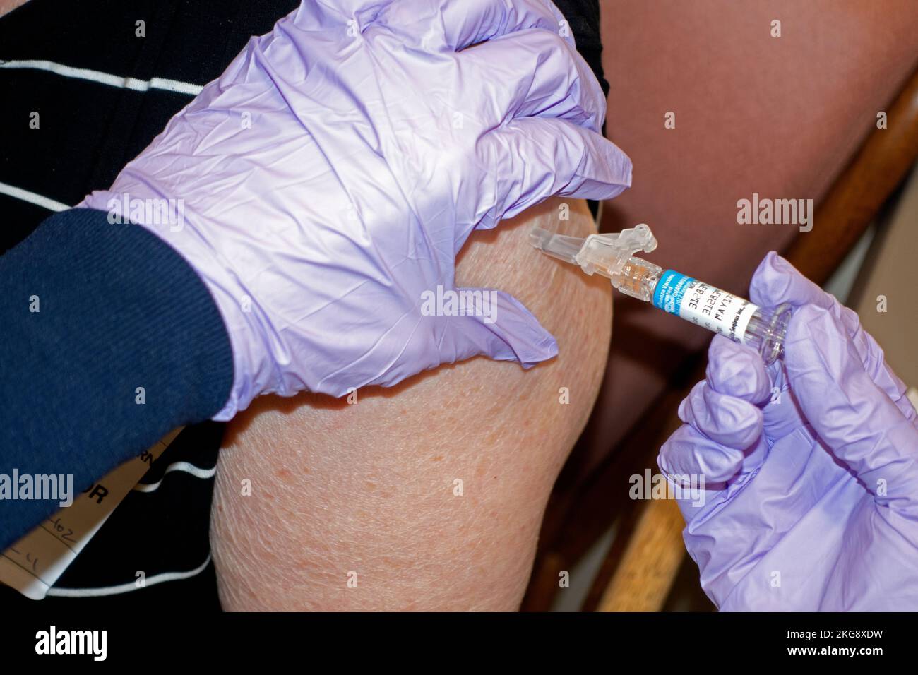 Woman age 80 being vaccinated with her annual influenza flu vaccine at a local pharmacy. Ouch! Minneapolis Minnesota MN USA Stock Photo