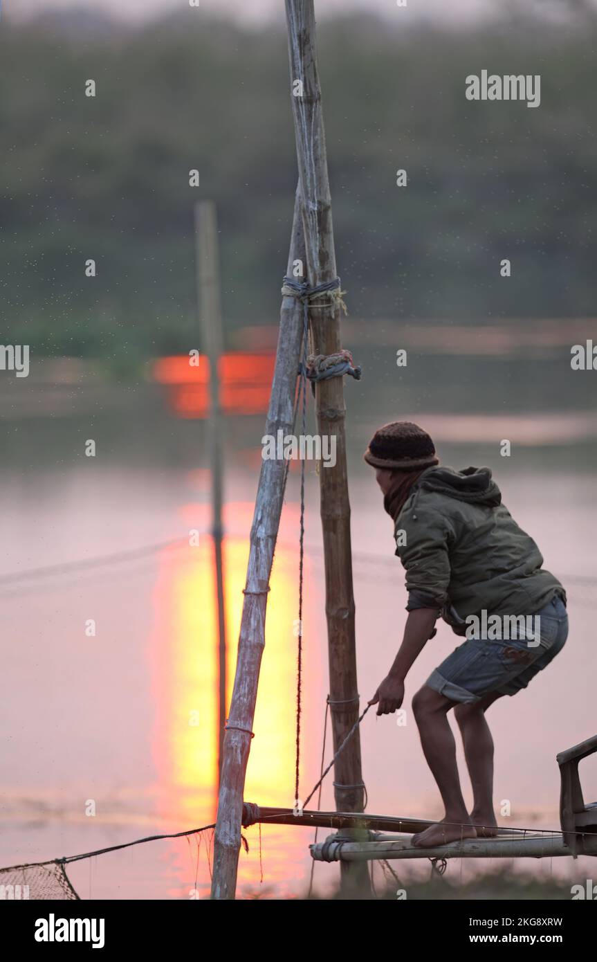fisherman setting nets in the setting sun  Dibru-Saikhowa, Assam, India                 February Stock Photo