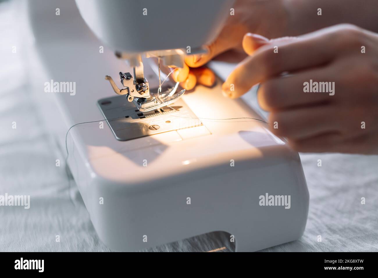 Lady threading a sewing machine needle Stock Photo Alamy