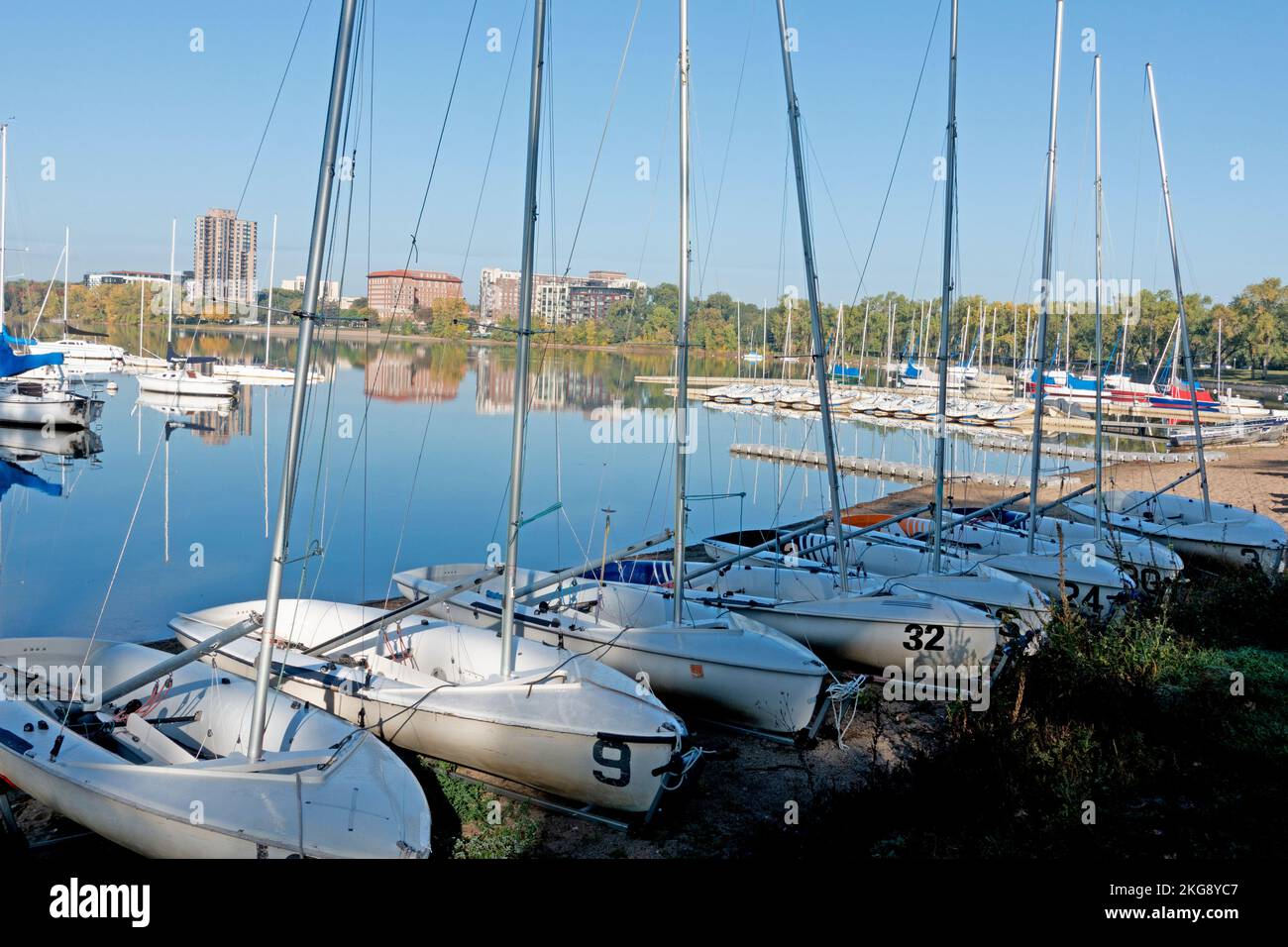 Lake Bde Maka Ska (was Lake Calhoun) quiet and calm with sailboats anchored in the water and moored on the shore. Minneapolis Minnesota MN USA Stock Photo