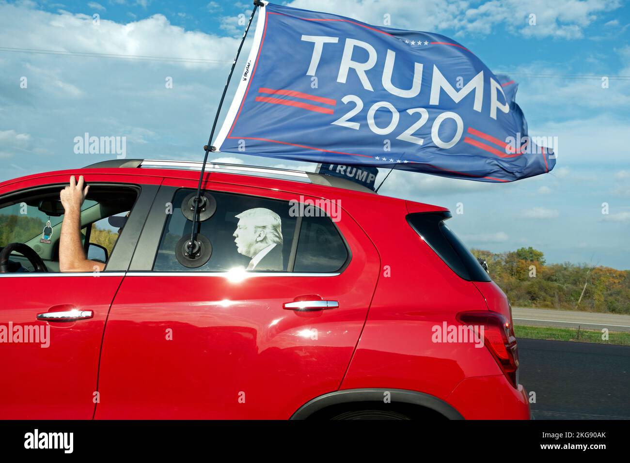 Red car on the highway showing support for Trump 2020 cardboard cut out of Trump in the car. Minneapolis Minnesota MN USA Stock Photo