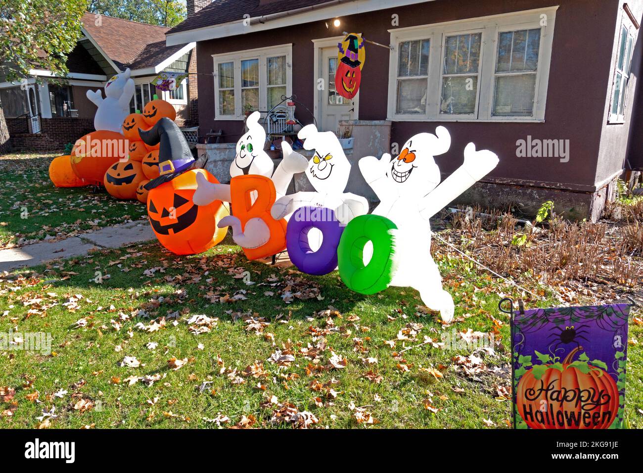 A jolly group of blow-up Halloween ghosts and jack-o'-lanterns holding the large letters Boo. Fergus Falls Minnesota MN USA Stock Photo