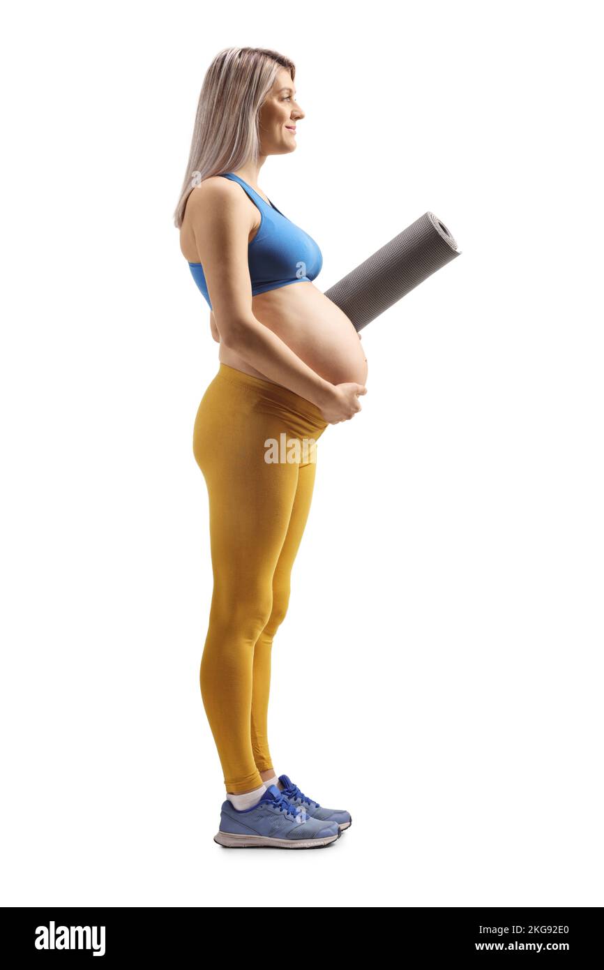 Full length profile shot of a pregnant woman in sportswear holding an exercise mat isolated on white background Stock Photo