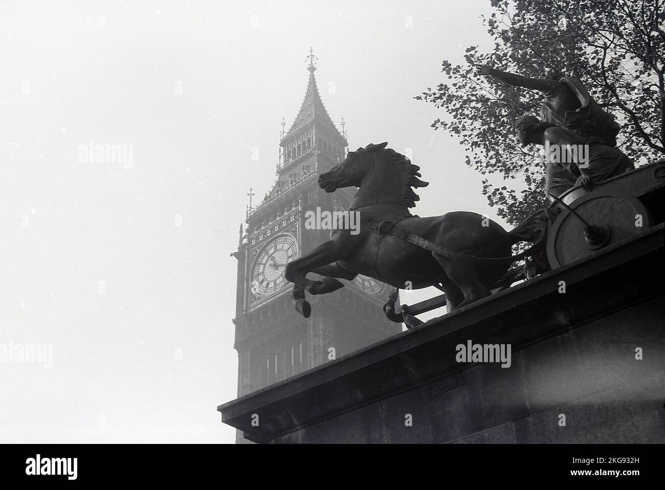 1950s, historical, a view of the Roman statue, 'Boadicea and Her Daughters' located in Westminster, seen against the Clock Tower (Big Ben) by the Palace of Westminter, home of the UK Goverment.  Representing Boudica, queen of the Celtic Iceni tribe who led an uprising in Roman Britain, the sculptor was Englisih artist and engineer, Thomas Thornycroft. Although completed in 1885, it was not until 1902 that it was cast in bronze and installed on the north side of Parliament Hill. Stock Photo