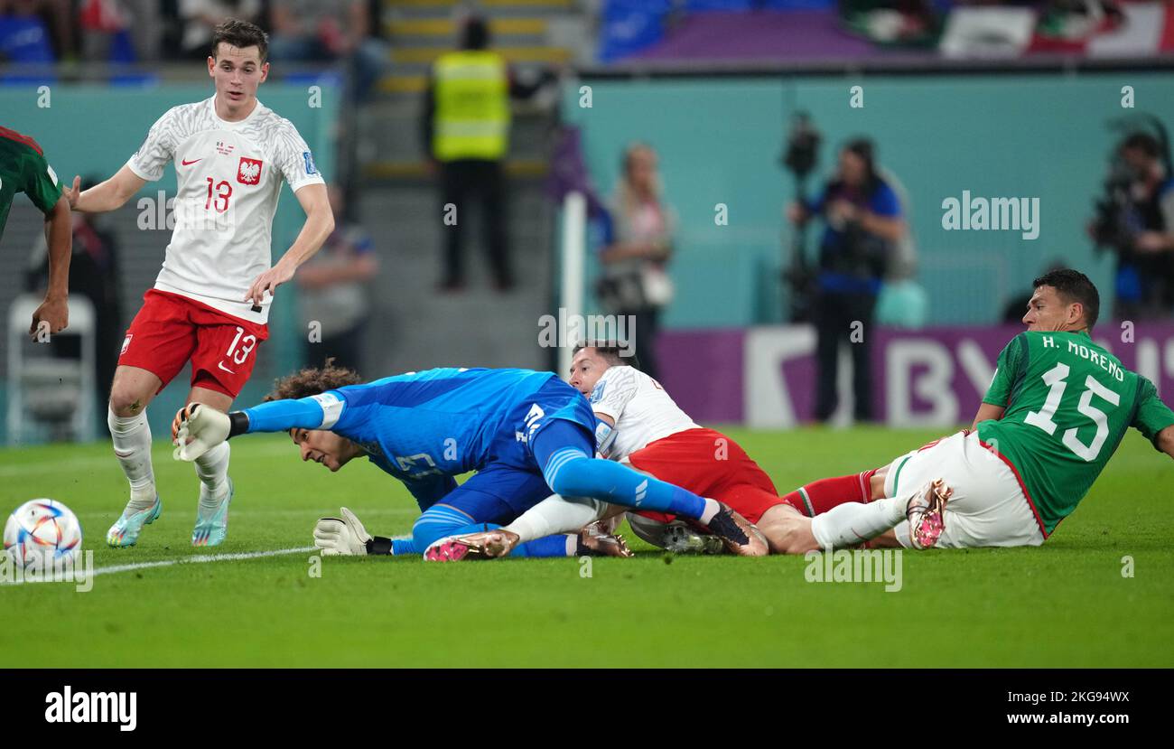 Mexico's Hector Moreno (right) fouls Poland's Robert Lewandowski, resulting in a penalty during the FIFA World Cup Group C match at Stadium 974, Rass Abou Aboud. Picture date: Tuesday November 22, 2022. Stock Photo
