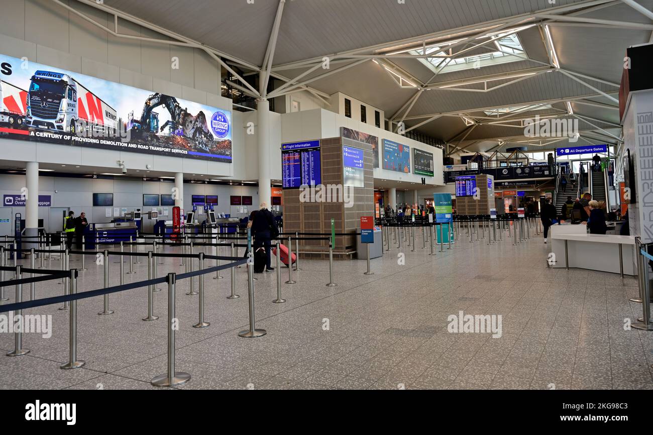 Bag drop and check in at Bristol Airport terminal with measures for crowd queue control in lines with movable barrier stanchion gates Stock Photo