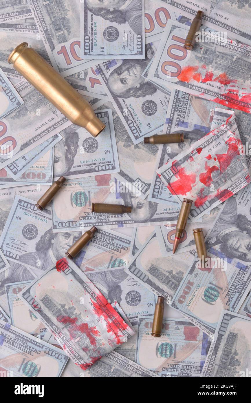blood money of war. Cartridges with blood in dollar bills. Stock Photo