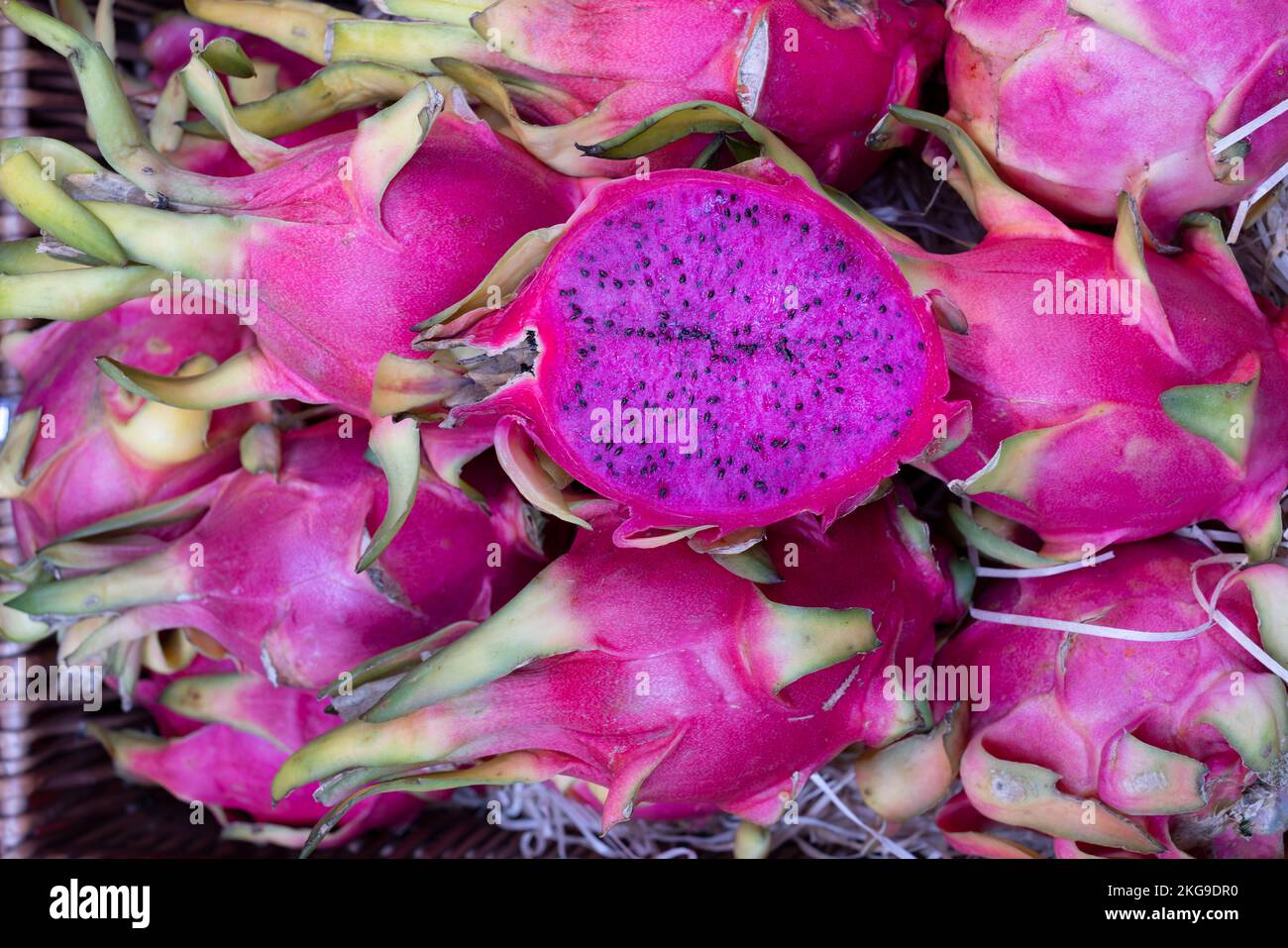 Red Dragon Fruit Hylocereus costaricensis or pitahaya a tropical fruit. The fruits, one cut in half, are for sale in an English fresh produce market Stock Photo