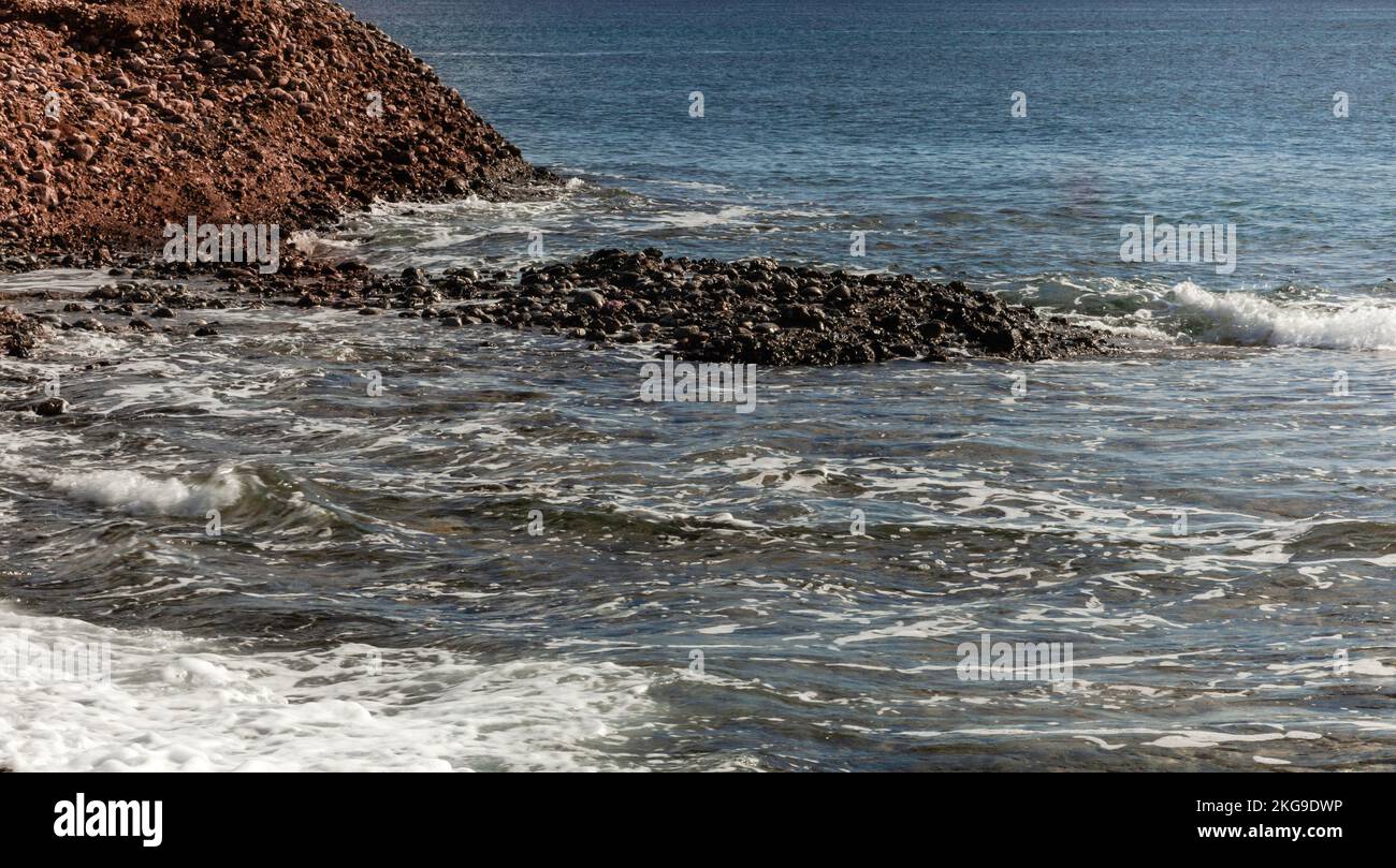 An unspoiled seaside view with small views and stones. Stock Photo