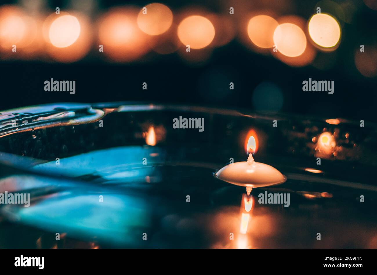 nutshell with burning candles floating on water surface in dark, European christmas tradition