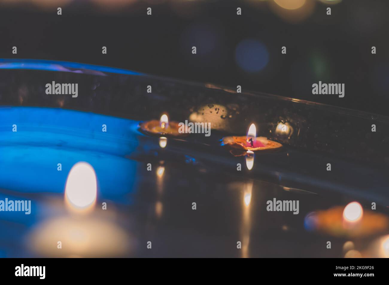 nutshell with burning candles floating on water surface in dark, European christmas tradition