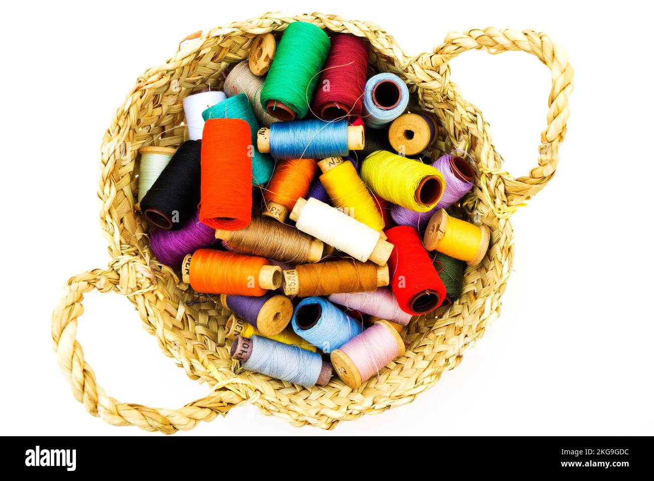 Wicker basket with balls of knitting yarn on white background, close up ...