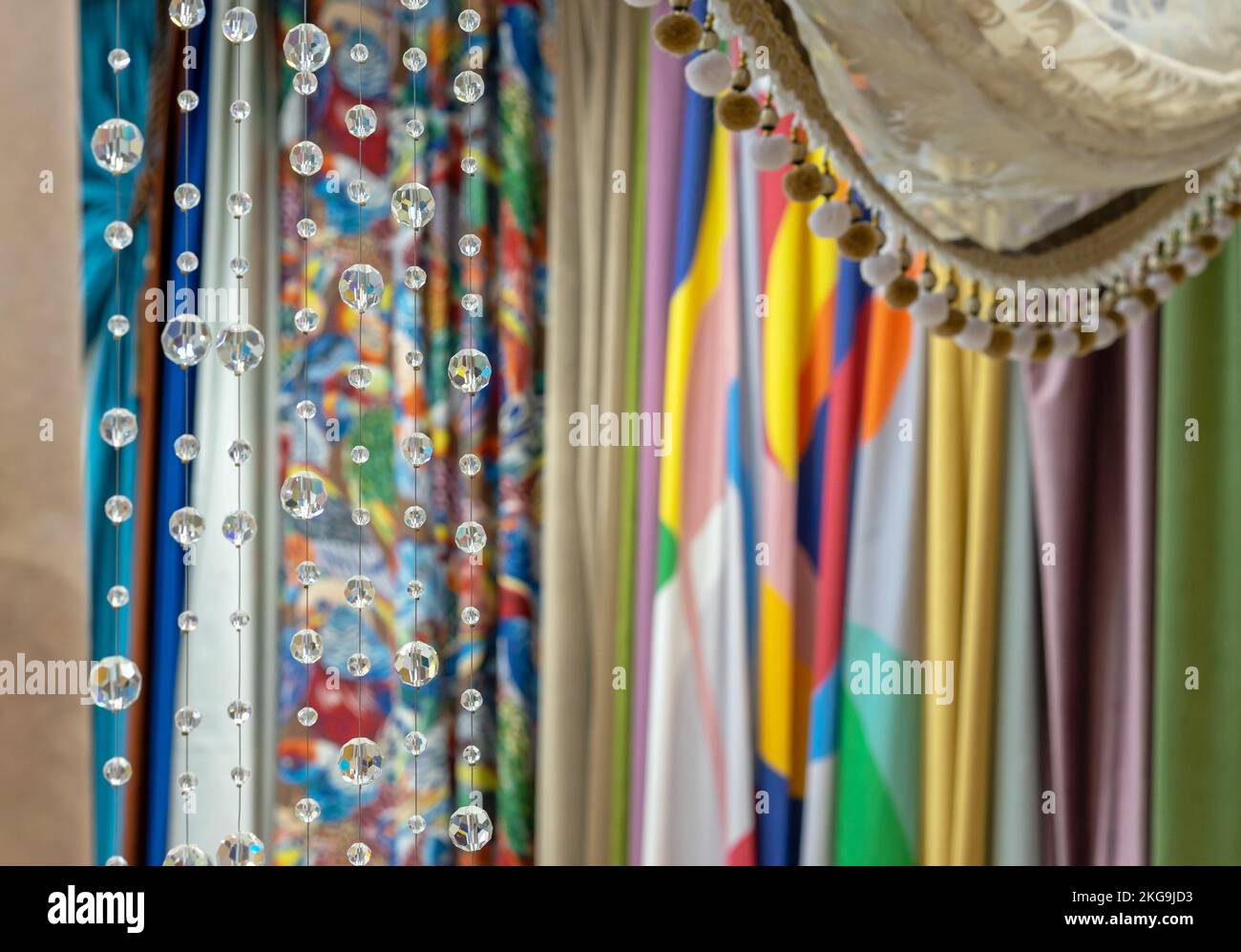 Decorative glass beads against the background of bright fabrics. Crystals in the interior. Stock Photo