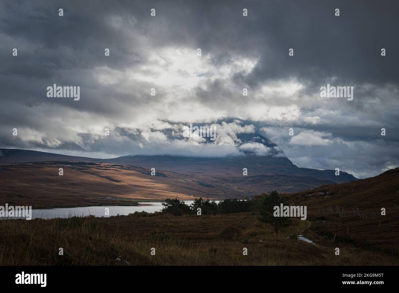 A dramatic autumnal HDR of Ben Hope partially covered by low cloud, with Loch Hope below, Sutherland, Scotland. 24 October 2022 Stock Photo