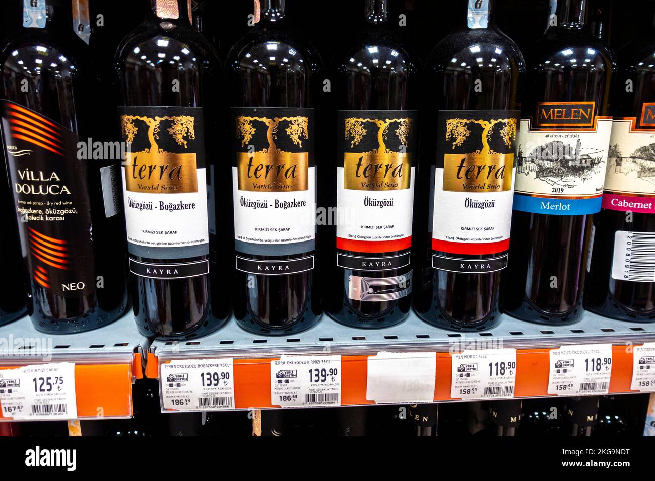 Turkish red wine bottles on a supermarket shelf. Wine from Turkey with price tags. Terra Okuzgozu Kirmizi wine from Turkey, bottle. Stock Photo