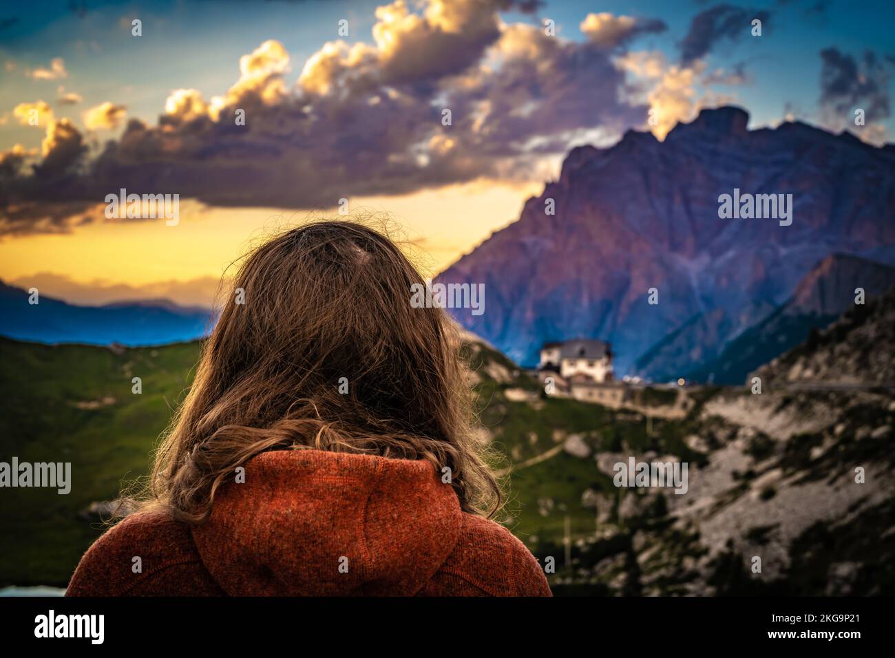 Description: Sporty woman in outdoor jacket watches beautiful sunset