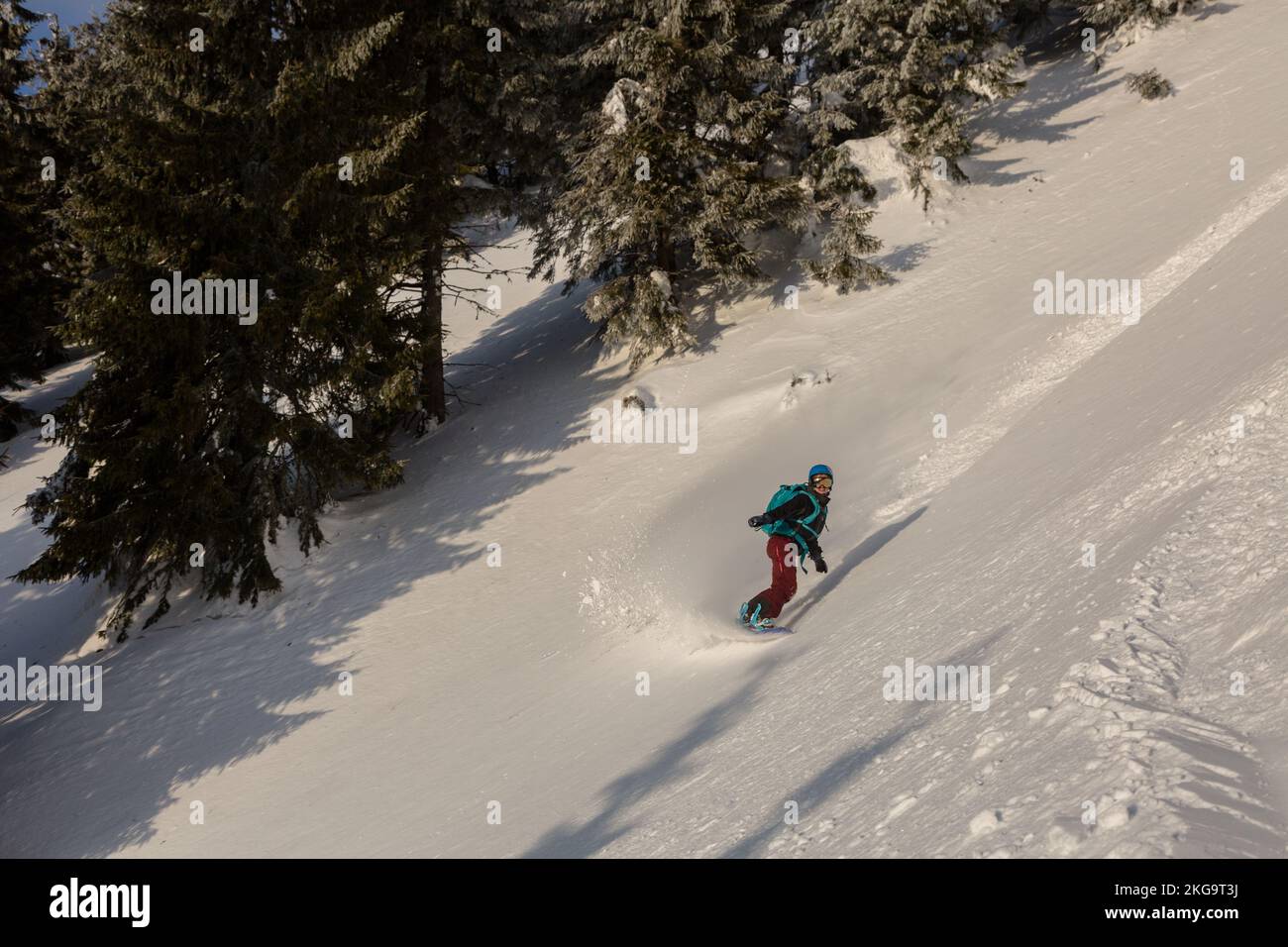 A female rider on a snowboard freeriding in a backcountry alpine