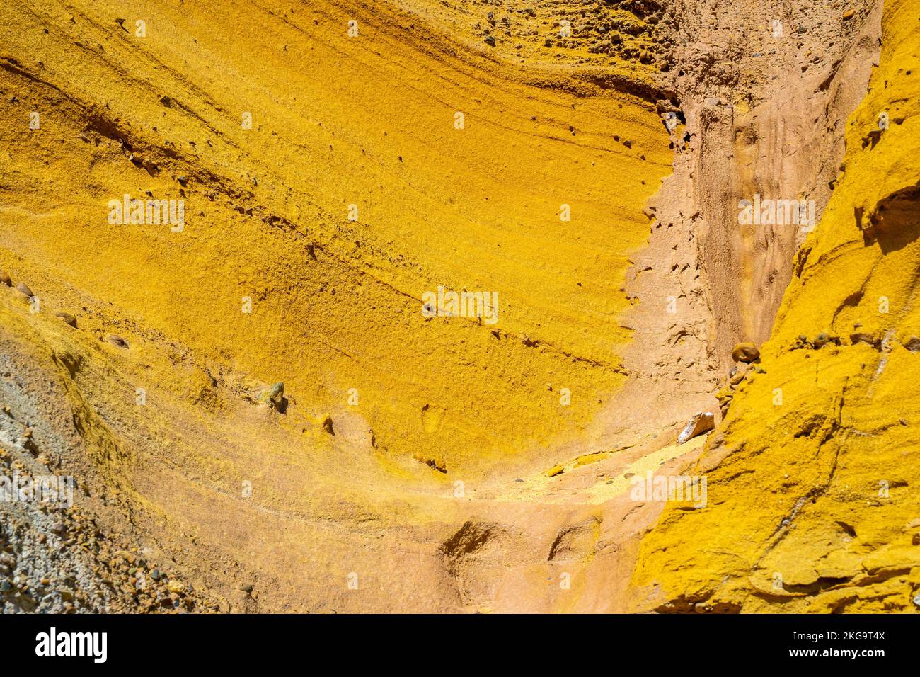 Multicolored yellow, mustard, honey colored colourful colorful rock slope texture weathering and erosion, patterns and textures of rock formation Stock Photo