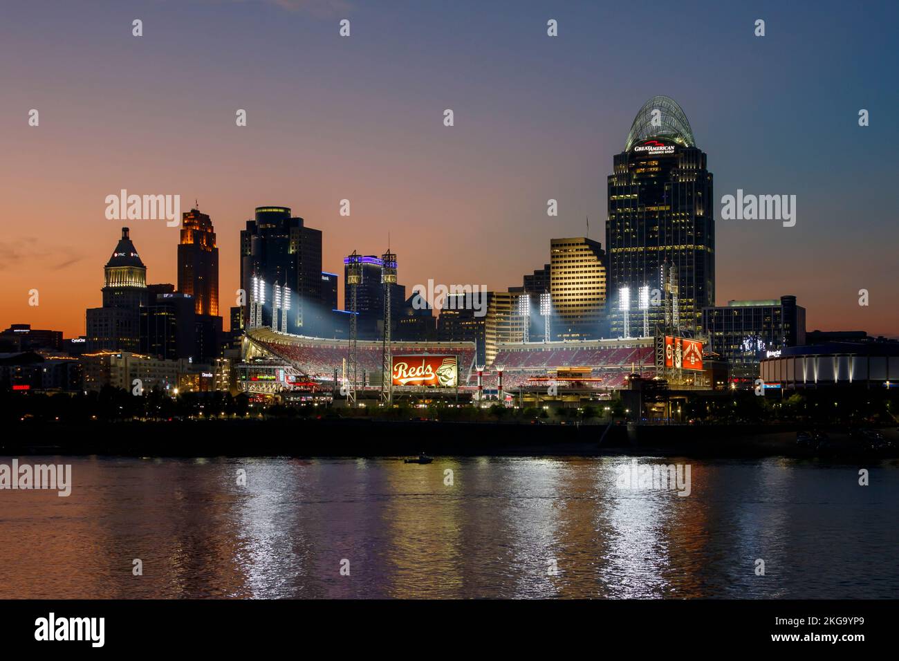 Cincinnati, Ohio, skyline at dusk. Cincinnati Reds baseball sign and stadium near center. Viewed across the Ohio River from Newport, Kentucky, USA. Stock Photo