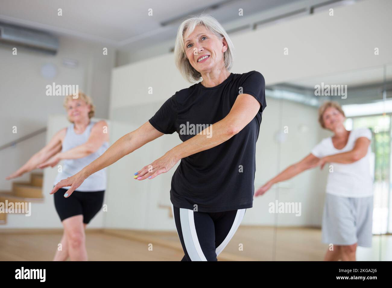 Active mature woman learning dynamic dances in choreography class Stock Photo