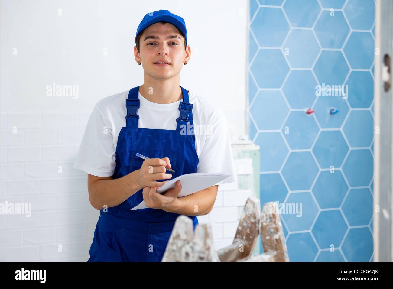 Young foreman making task list during works in building under construction Stock Photo