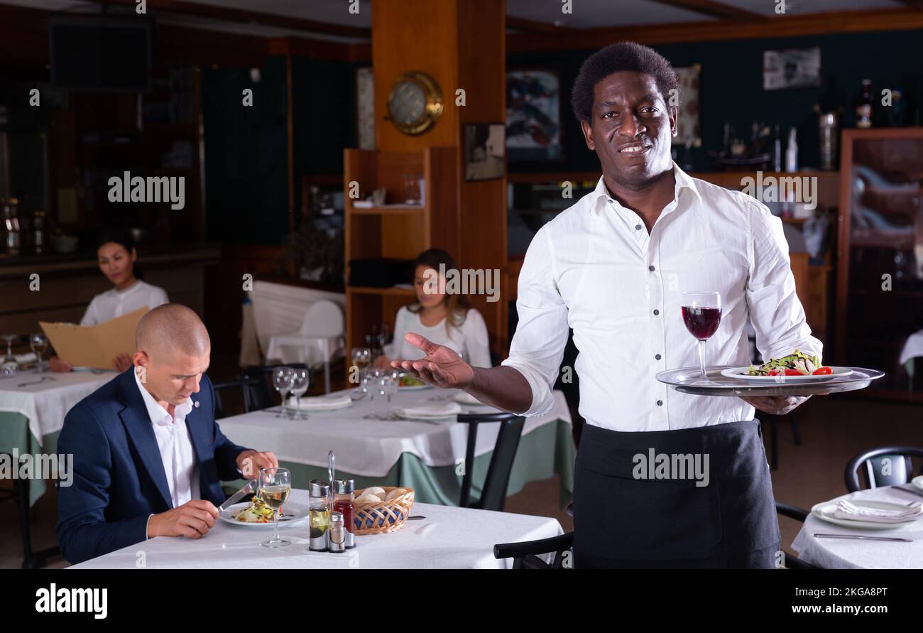 portrait of happy male garson standing in cafe Stock Photo