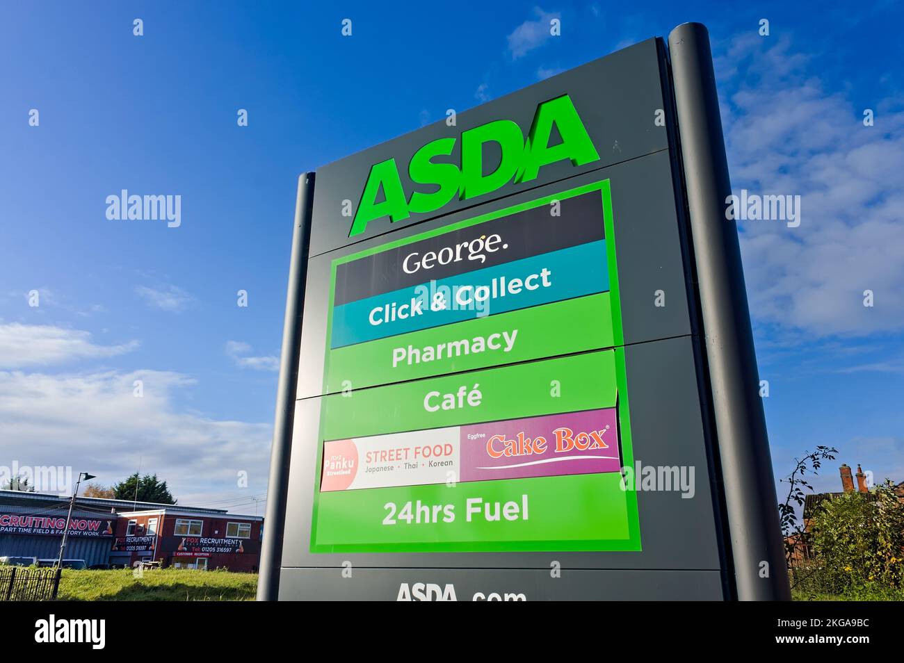 looking up at the billboard brand sign for the ASDA superstore with a blue sky background Stock Photo