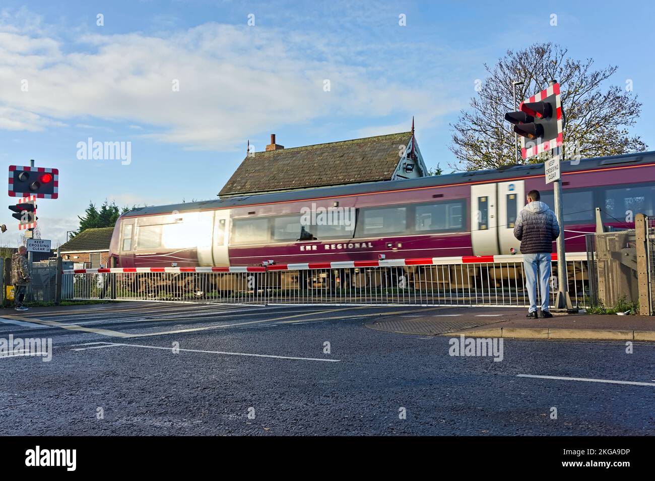 East Midlands regional train passing by an automated railway crossing. Stock Photo