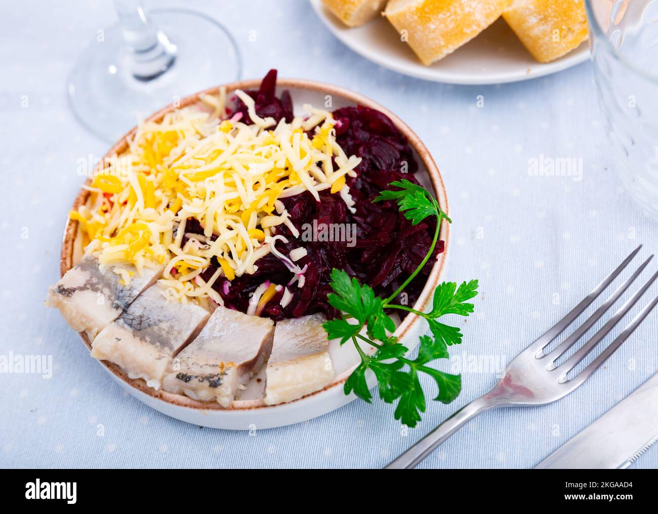 Sliced herring with grated beetroot and cheese served on table Stock Photo