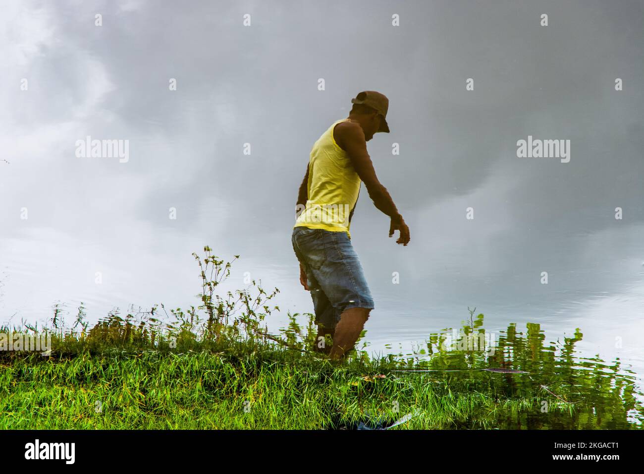 Reflection in the water of a man pulling a rope on the bank of the Jaguaripe River in the City of Aratuipe, Stock Photo