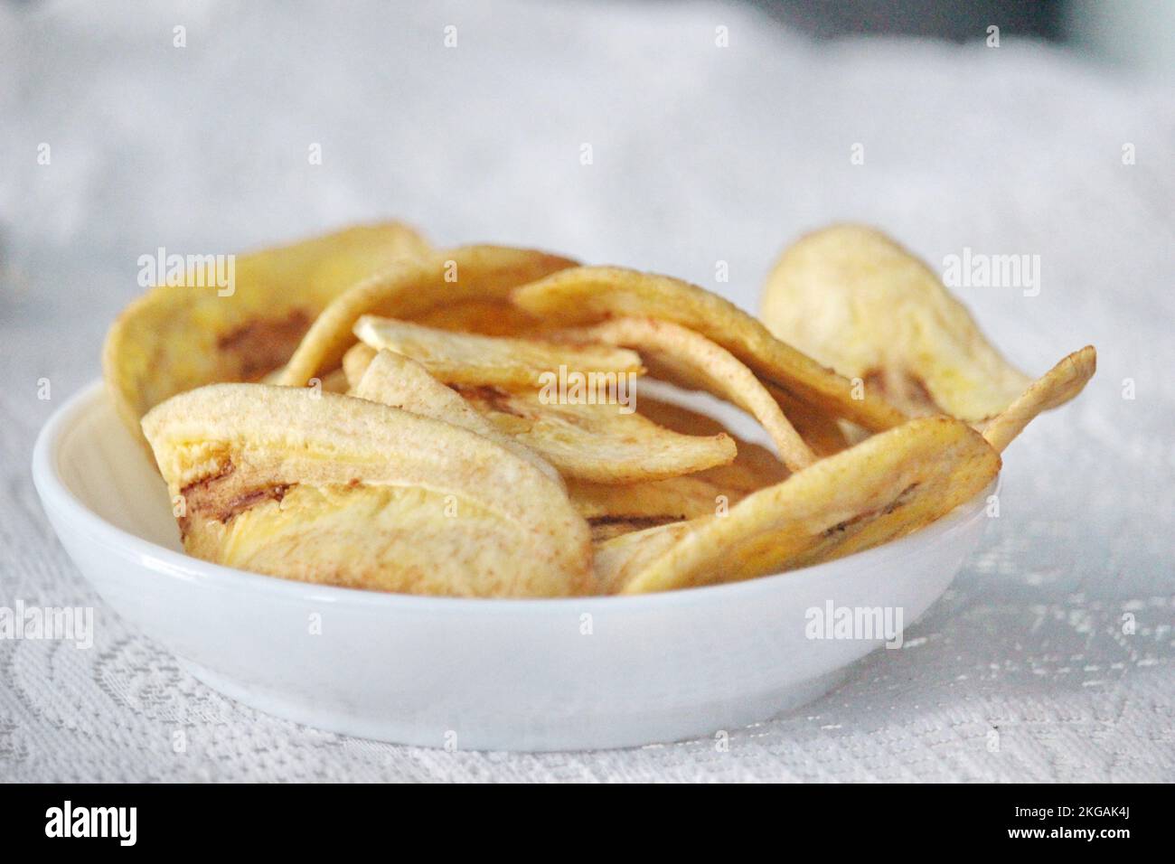 Banana chips in a white plate on a white background ready for sale