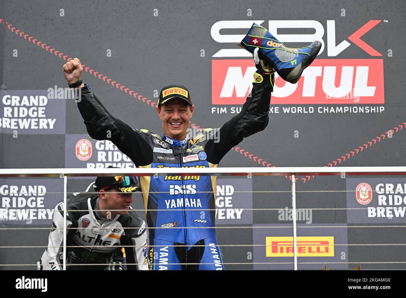 Dominique Aegerter celebrates victory in the World Supersport on the podium in Australia, raising his race boot ready for a shoey. Stock Photo