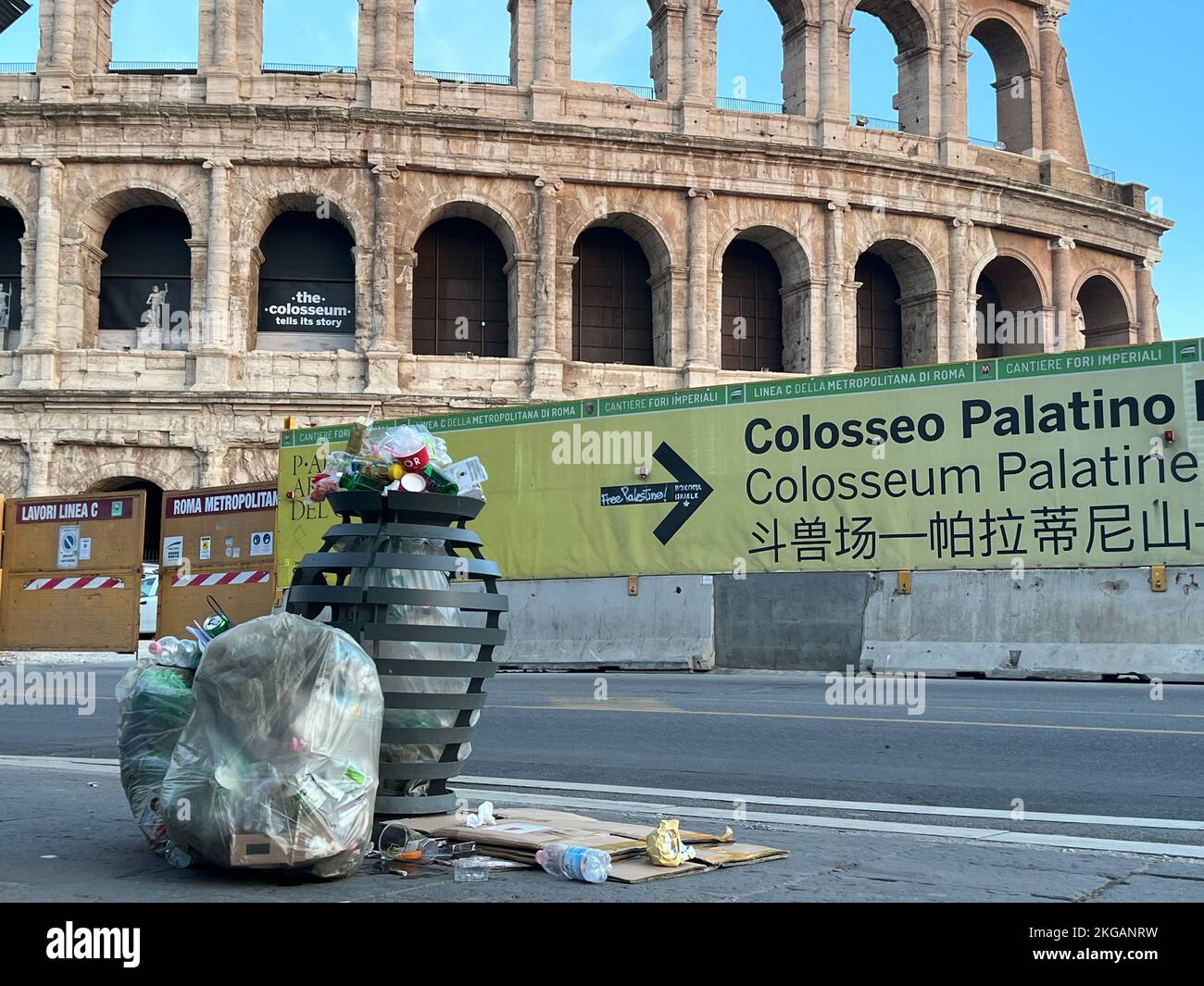 Bags of garbage in and next to the trash can at the Colosseum in the