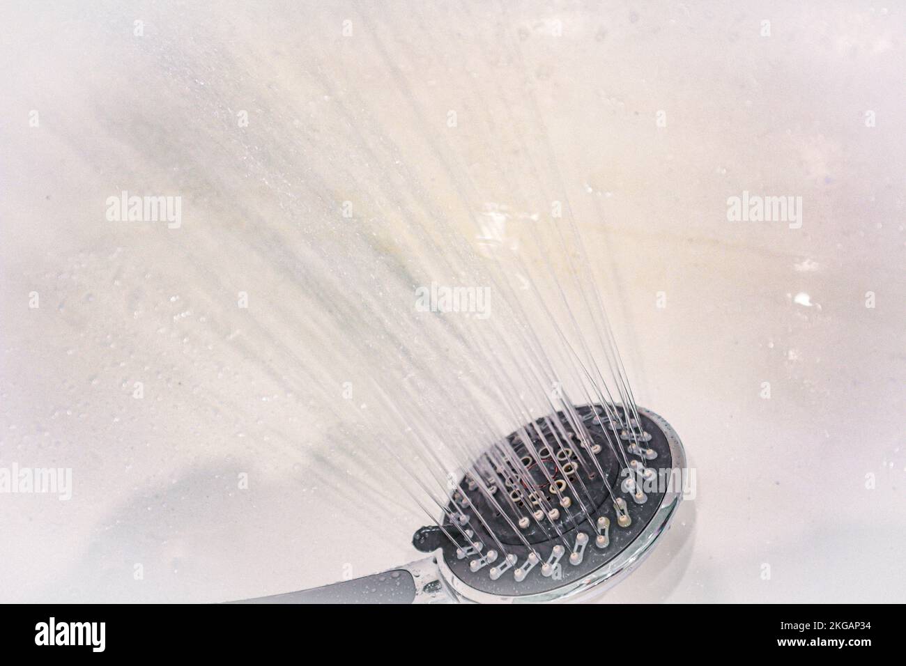 Drops of water fall from the watering can in the shower closeup. The