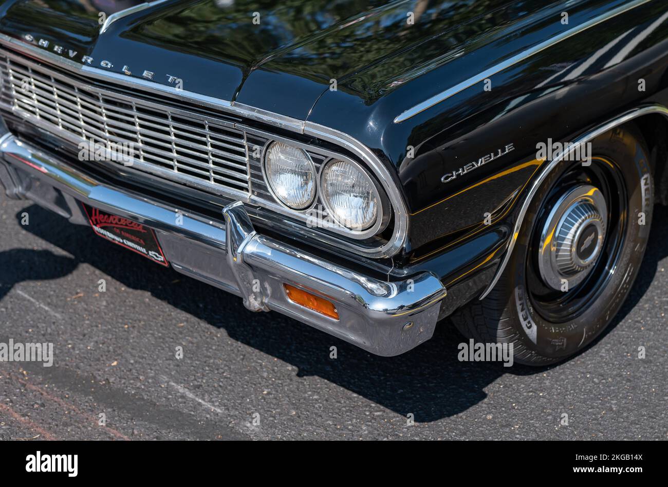 NISSWA, MN – 30 JUL 2022: Front end of a restored vintage black Chevrolet Chevelle automobile or car, with left headlights, bumper, grille and wheel. Stock Photo