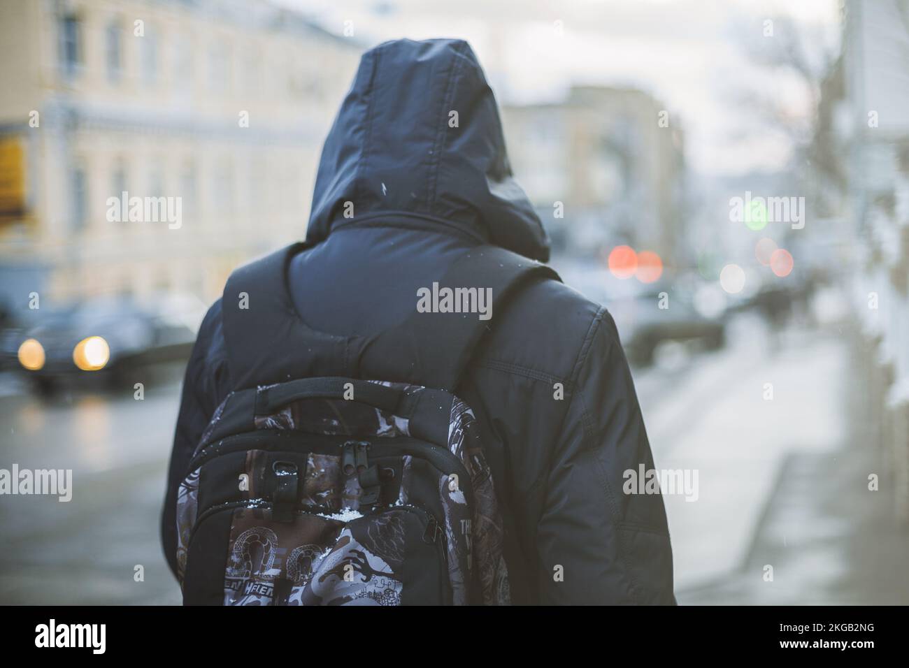 Student with backpack walking through foggy city street Stock Photo