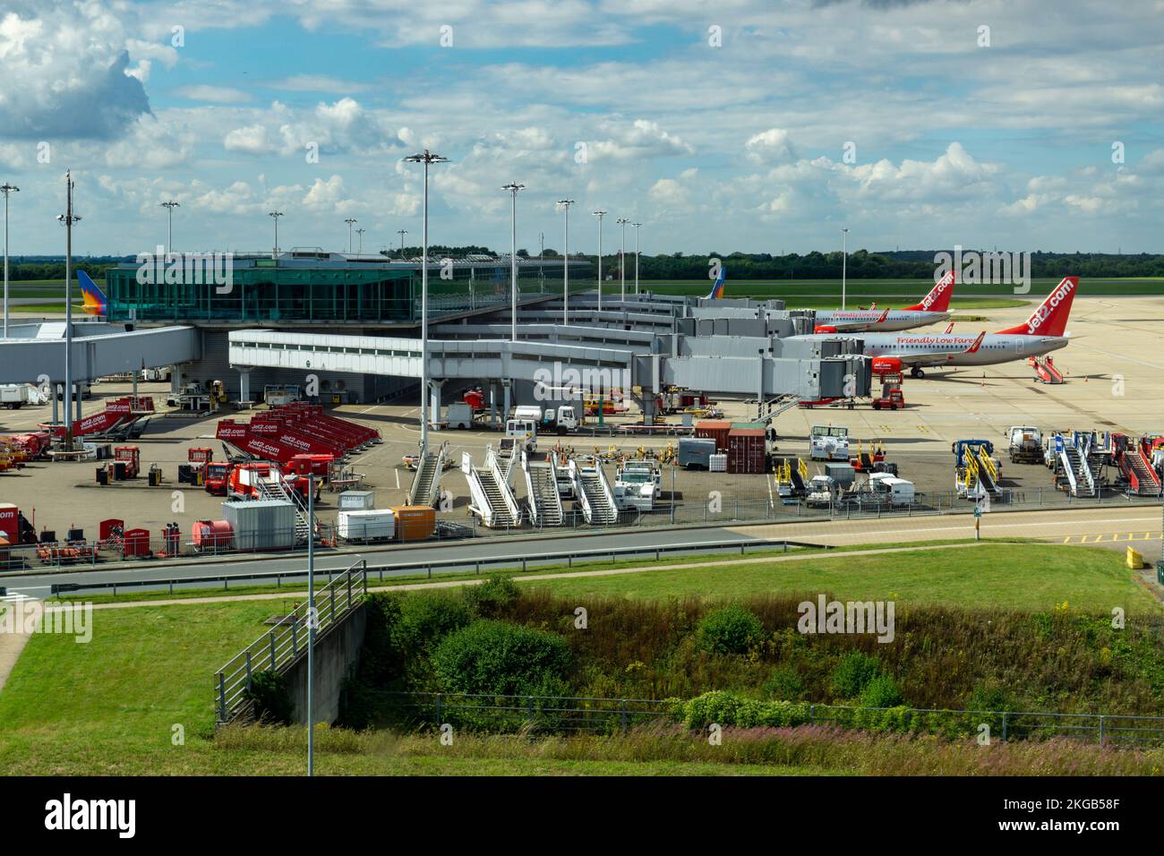 Passenger planes at Stansted Airport in the loading area and runway in the background Stock Photo