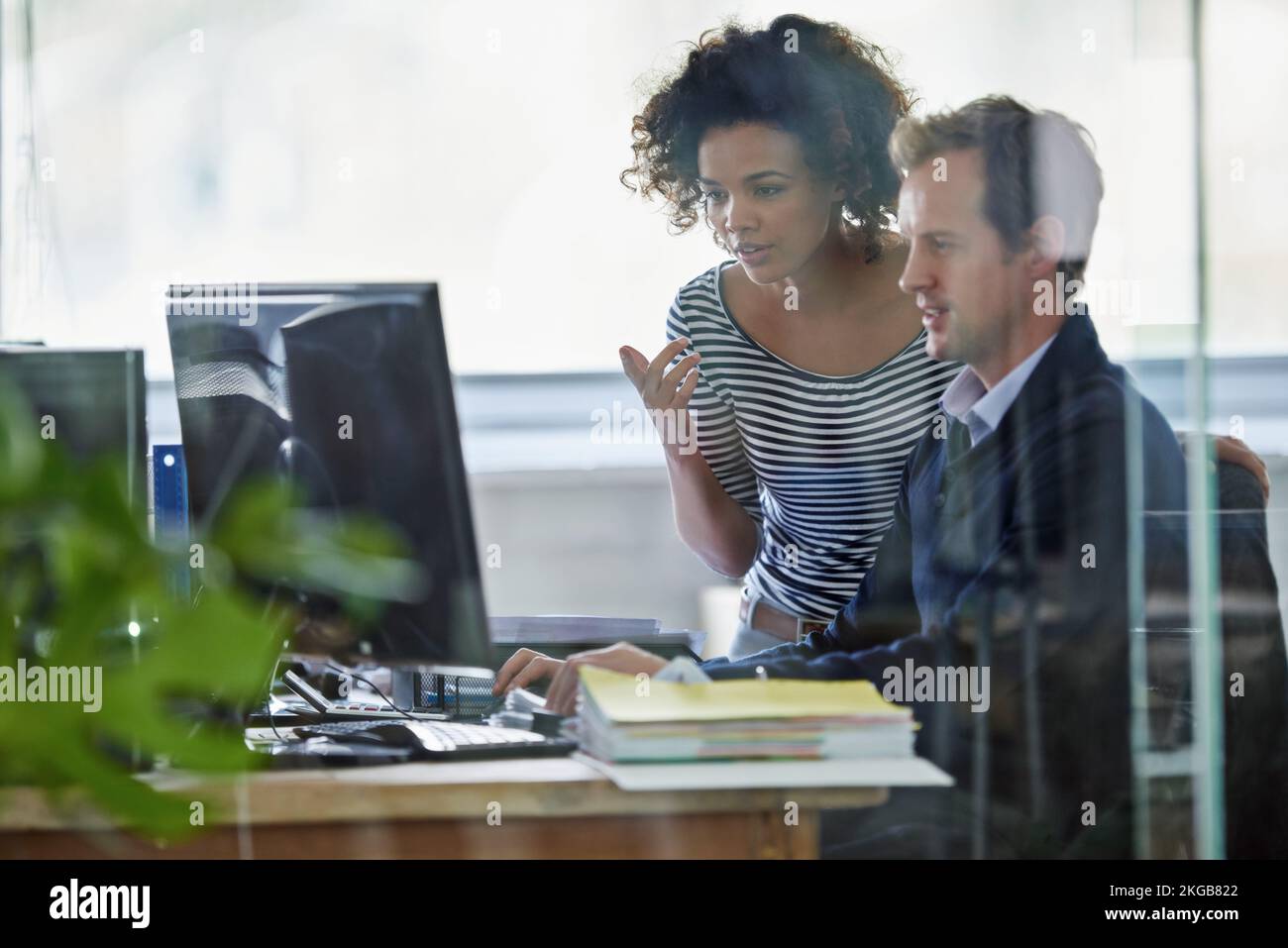 Voicing some ideas. two young designers working on a pc. Stock Photo
