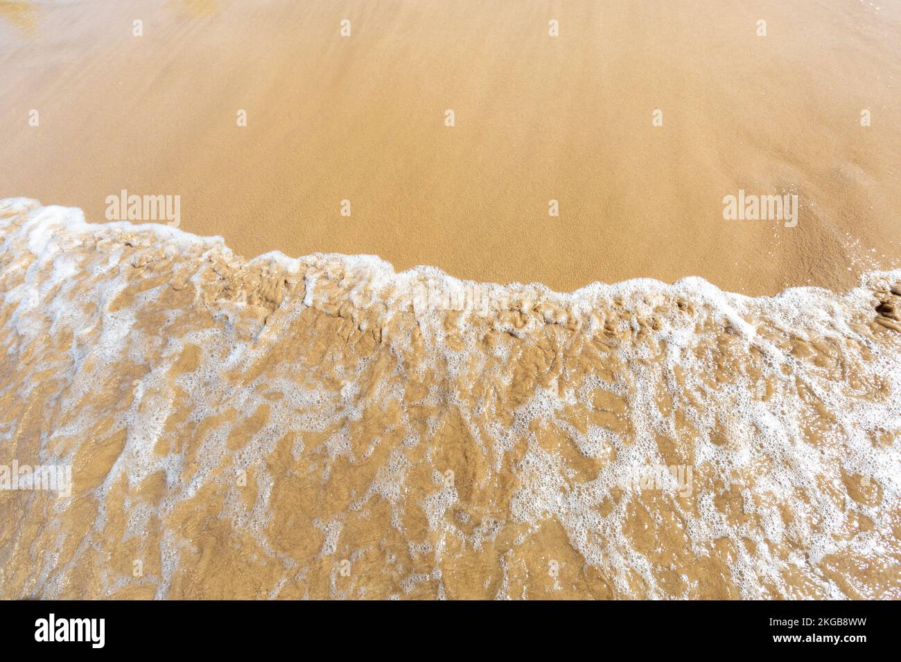 Ocean beach aerial top down view with blue water, waves with foam and spray and fine sand, beautiful summer vacation holidays Stock Photo