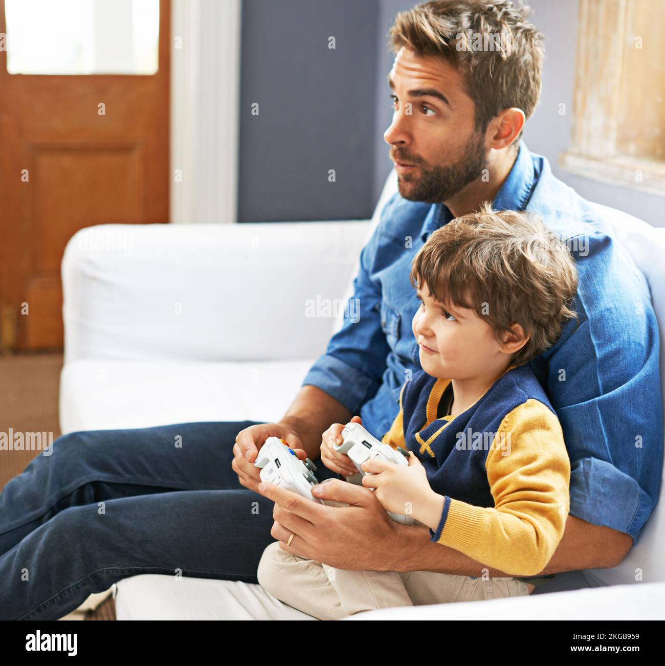 Father and Son Playing Video Games --- Image by © Royalty-…